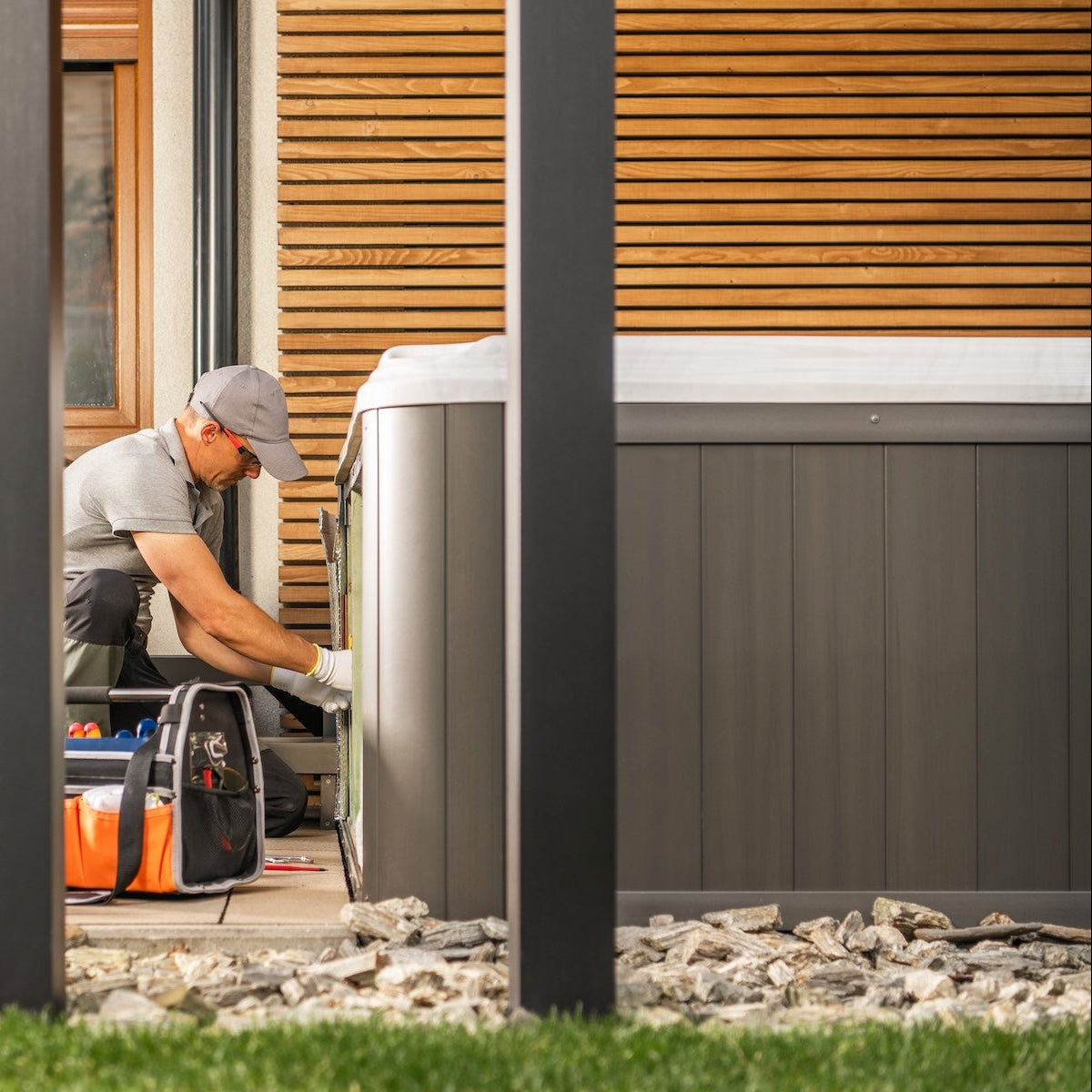 Vakman van Nordique Wellness voert onderhoud uit aan jets van een spa met warm water.